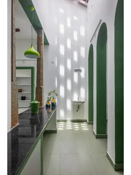 An interior corridor in the 'House of No Windows'. Instead of windows, the design uses perforations in the wall to create a dynamic play of light and shadow, providing ventilation while ensuring privacy.
