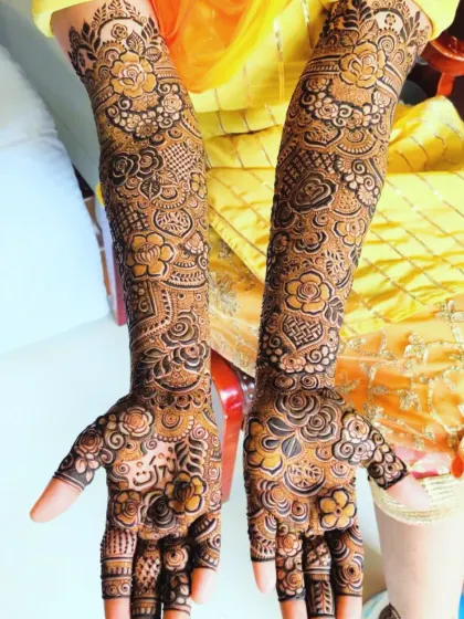 A bright and beautiful bridal design with a focus on floral bands at the top of the arm and a mix of traditional patterns below.