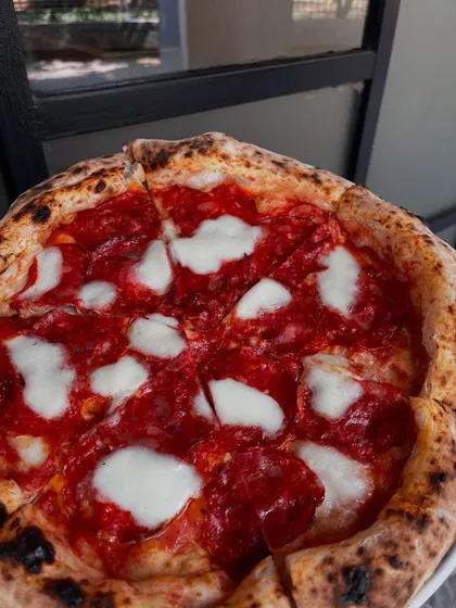 A classic Margherita pizza, sliced and ready to eat. The perfect choice for any occasion.