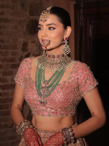A close-up of the Anand Karaj bride's stunning makeup and jewellery. The focus is on her luminous skin and the intricate details of her nath and layered necklaces.