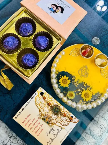This beautiful Rakhi hamper includes a decorative thali, chocolates, and a designer rakhi, all beautifully packaged for gifting.