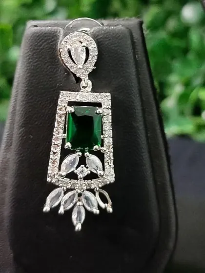 A detailed view of the matching earring for the diamond-look set. The design features a central green stone surrounded by marquise and round-cut cubic zirconia.