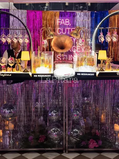 A vibrant, retro bar setup for a disco-themed birthday party. We used shimmering tinsel curtains, disco balls, and neon signs to create a groovy and energetic atmosphere.