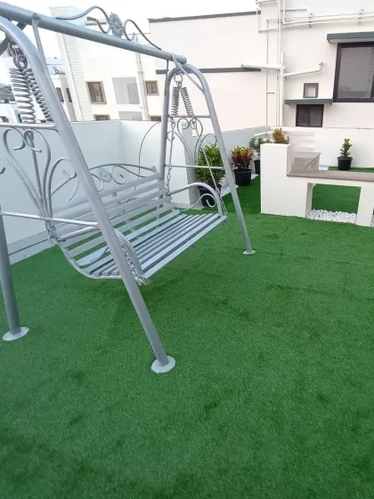 A close-up of the garden swing on the new rooftop lawn. The artificial turf provides a soft and durable surface that stands up to furniture and foot traffic.