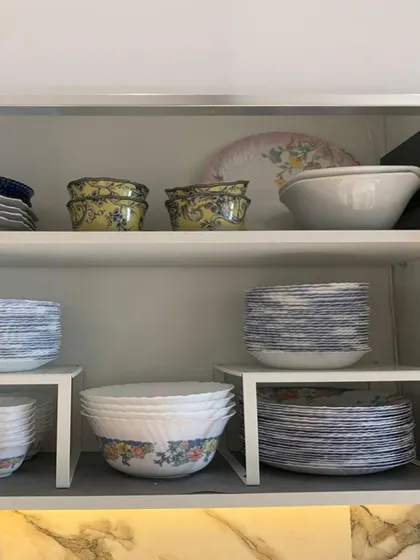 We used white risers to organize this collection of Corelle dinnerware. The risers help define the space and prevent stacks from becoming too high and unstable.