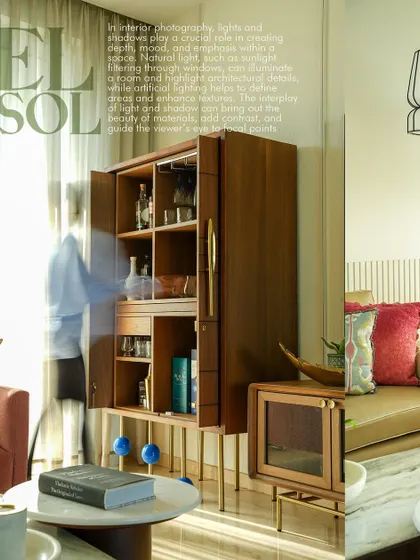 This image captures a wider view of a living room, showcasing a handsome wooden bar cabinet as the focal point. The motion blur of a person on the left adds a sense of life and movement, making the space feel dynamic and lived-in, a key aspect of my residential interior photography style.