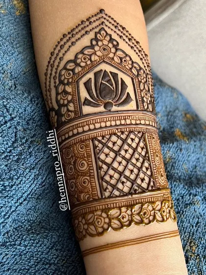 A beautiful beginning for an arm design. This cuff-style patch features a bold lotus, delicate beadwork, and intricate net patterns, setting the stage for a stunning bridal henna.
