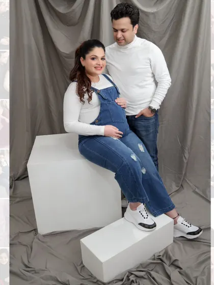 A classic seated maternity pose in our studio. The couple shares a quiet, happy moment, with the focus on the baby bump and their connection.