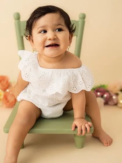 A bright, cheerful smile from her seat on the little green chair. This sitter session is full of personality and charm.