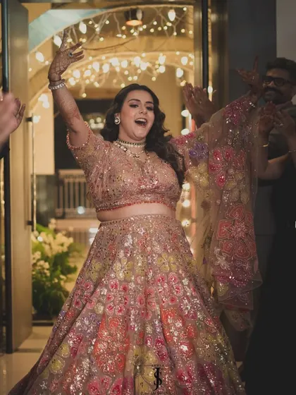 Making a grand entrance at her Sangeet. This bride is all smiles in a magnificent floral lehenga by Seema Gujral.