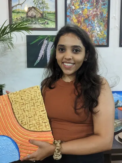 A participant with her unique texture painting, which incorporates a woven pattern.