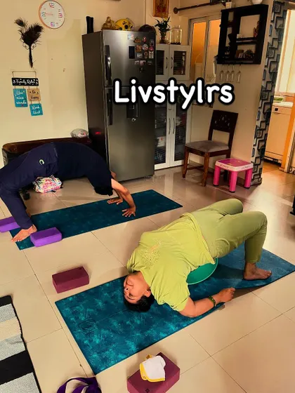 Two clients in different back-bending poses, one in Urdhva Dhanurasana (Wheel Pose) and the other in a supported bridge. This shows the variety and progression in our classes.
