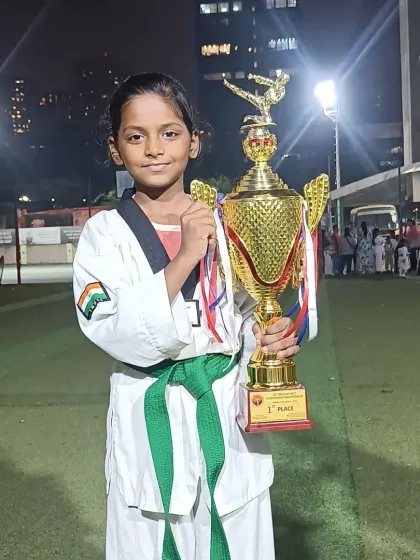 A young girl proudly holds the team's championship trophy. Every student plays a part in our success.