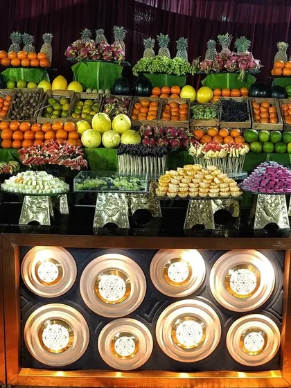 A fresh fruit and dessert display on an Art Deco style counter. I arranged a wide variety of colorful, seasonal fruits and sweets at different heights to create an abundant, market-style look.