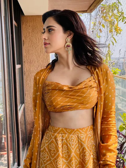 This mustard yellow bandhani print co-ord set on Nushrratt Bharuccha is perfect for a festive daytime event. The draped top and matching jacket are so chic.