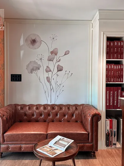 A timeless brown leather Chesterfield sofa, a symbol of classic sophistication. I placed it in my showroom to demonstrate how it can anchor a reading nook or a formal living area.