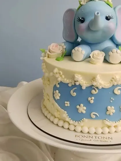 A side view of the cute baby elephant cake, showing the delicate piping work on the side.