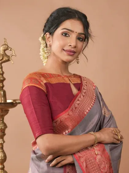 A model pairs a traditional silk blouse with a simple gold bracelet and rings, showing that sometimes less is more.