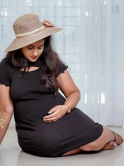 A simple and sweet solo portrait in a casual black dress. The sun hat and flower basket add a touch of rustic charm to the clean studio look.