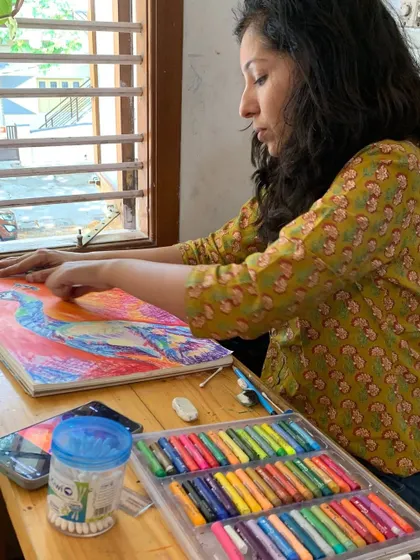 A student works with a colorful array of soft pastels. This medium allows for direct, hands-on blending and layering, creating a unique connection between the artist and their work.