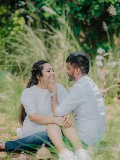 An intimate moment in a beautiful green space. The groom's gentle touch and the couple's loving gaze make this a very romantic and natural-feeling portrait.
