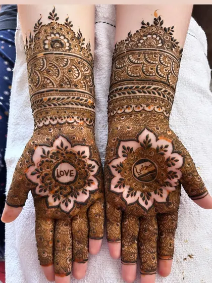 A beautiful mandala design with the word 'LOVE' hidden in the center, surrounded by intricate patterns extending up the arm.