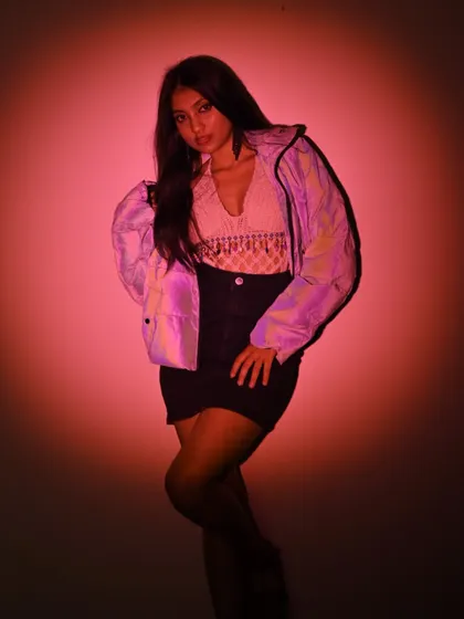 A dynamic pose from the same photoshoot, showing off the full outfit and confident stance.