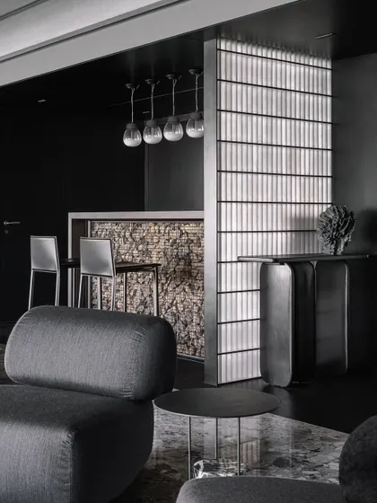 The bar area, separated from the entrance by a frosted glass brick partition that creates a soft, ambient glow.