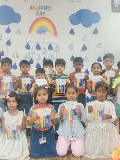 A full class photo of our shining stars with their rainbow crafts, a testament to a day filled with color and creativity.