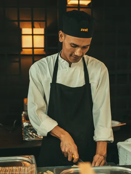 A smiling chef chops ingredients, reflecting the positive energy of our team.