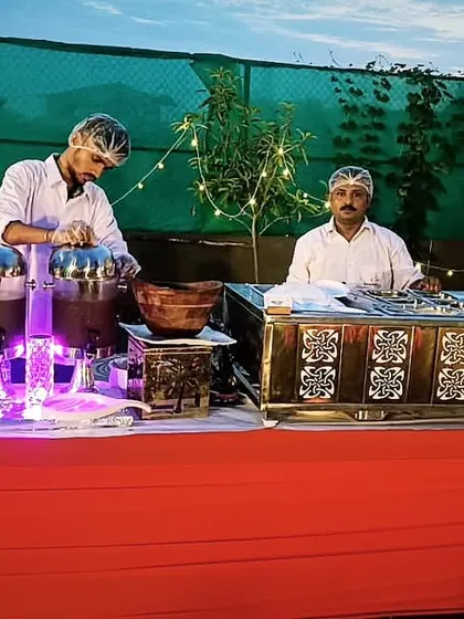 A vibrant chaat counter set up for an evening event. The twinkling lights and delicious street food create a magical and festive atmosphere.
