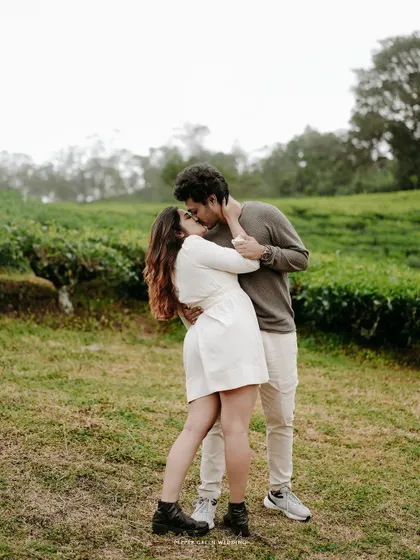 A passionate kiss shared between Sanchana and Adarsh in a verdant field. I aim to create a comfortable space where couples feel free to express their love openly.