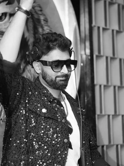 Hand in the air, feeling the energy of the room. A classic DJ pose.