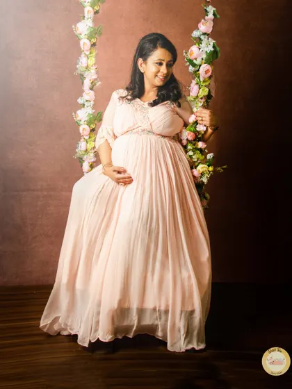 To add a touch of whimsy to your shoot, we have unique props like this beautiful floral swing. It creates a dreamy, romantic setting for solo portraits in one of our flowing maternity gowns.