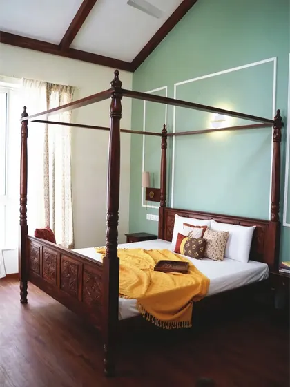 The centerpiece of a master bedroom, this magnificent four-poster bed is handcrafted from solid Sheesham wood. The detailed carvings on the headboard and the elegantly turned posts evoke a timeless, colonial charm, promising serene nights and beautiful mornings.