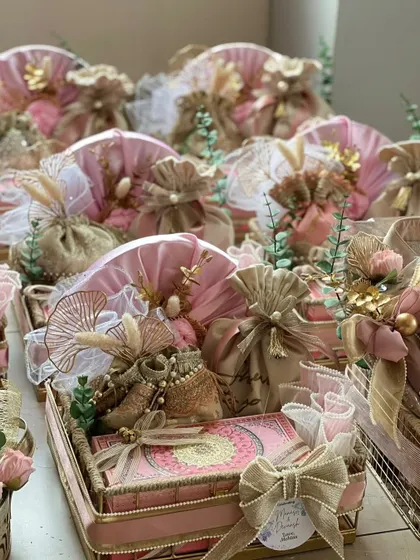 A bulk order of wedding invitation hampers ready for delivery. The consistent pink and gold theme, with small variations in arrangement, creates a stunning overall effect.