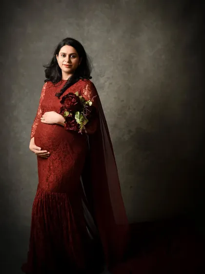 A classic standing portrait holding a bouquet. The cape-like trail of the gown adds a touch of elegance and drama to the silhouette.