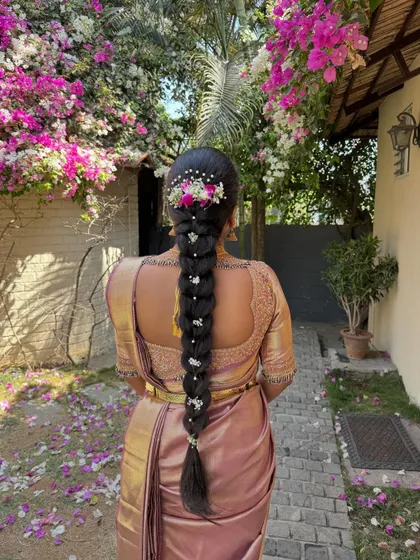 A traditional South Indian bridal braid decorated with fresh flowers and pearl accessories. This classic hairstyle is timeless and photographs beautifully.