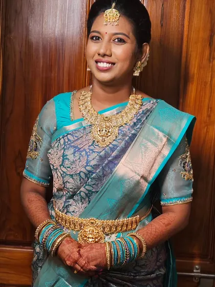 A simple and elegant look with a beautiful blue silk saree and traditional gold jewelry.