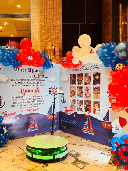 A "How Time Flies" photo wall at the nautical party, showcasing the baby's first year with a 360-degree photo booth.