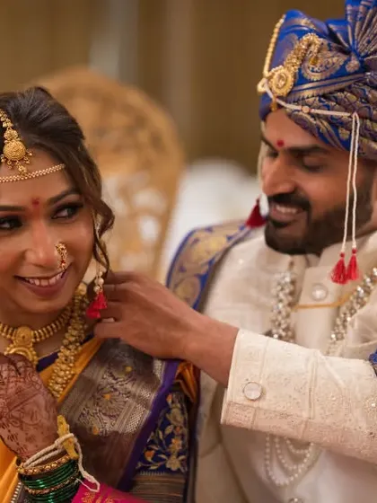 A candid, playful moment as the groom helps the bride with her jewelry. These are the unscripted memories we love to capture during a traditional Marathi wedding.