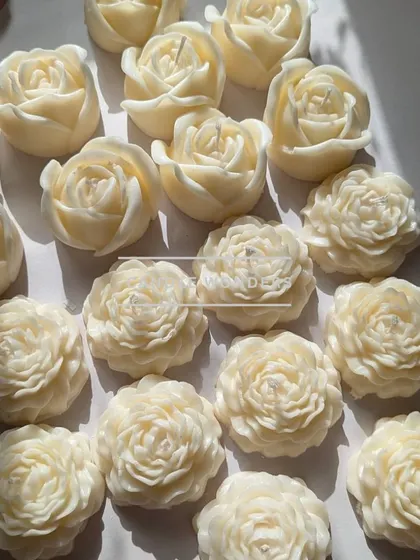 An array of white peony and rose candles, showcasing their delicate, handcrafted beauty.