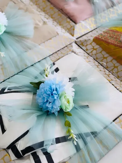 A beautifully wrapped gift for an engagement ceremony. The sea-green tulle and blue and white flowers create a fresh and elegant look.