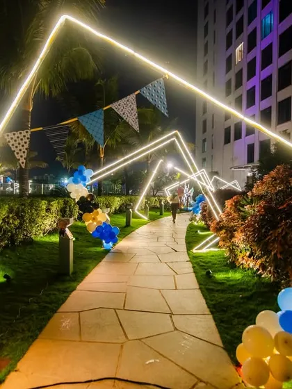 A modern and stylish entrance for a "Boss Baby" themed party. The walkway is lined with geometric light-up arches, creating a cool, tunnel-like effect that leads guests to the celebration.