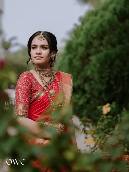 A thoughtful portrait of the bride, framed by green leaves, creating a natural and soft look.