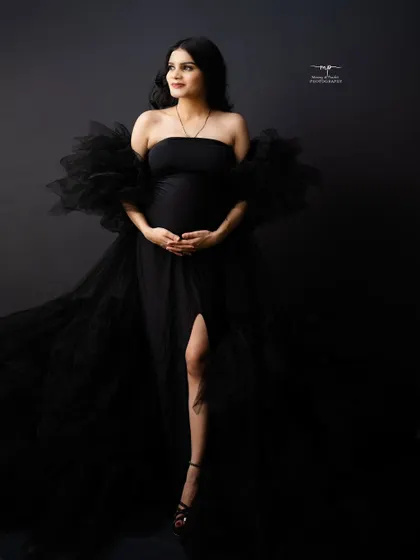 Another angle of this stunning black gown, showcasing its flowing fabric and the beautiful silhouette of the mother-to-be.