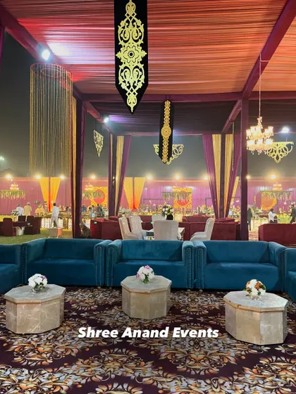 A beautifully composed shot of a lounge area with teal sofas, set against a backdrop of purple and gold drapes and hanging decor.