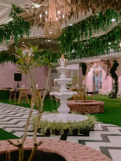 The result of our ballroom transformation for a Mehendi. We created a vibrant indoor garden with a central fountain, chevron-patterned flooring, and cozy seating nooks, proving that any space can become magical.