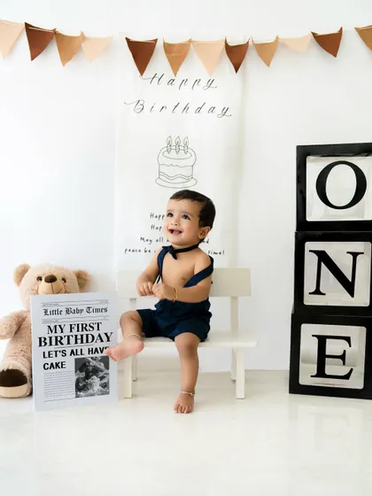 A happy smile from the birthday boy on his little white bench. I have a variety of props and furniture in my studio to customize your baby's first birthday shoot.