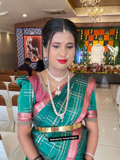 A beautiful, classic look for a family function. The client is wearing a green silk saree with pearl jewelry, and I created a look with a bold red lip and defined eyes.